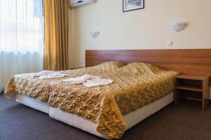 ein Schlafzimmer mit einem Bett mit zwei Handtüchern darauf in der Unterkunft Sandor Hotel in Nessebar