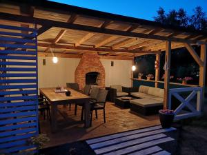 a wooden patio with a table and a fireplace at Domki Białogóra in Białogóra