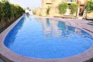 duży niebieski basen w budynku w obiekcie WelcomHeritage Ranjitvilas w mieście Amritsar