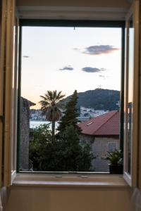 a window with a view of a palm tree at SeaBed Rooms&Studio Split in Split