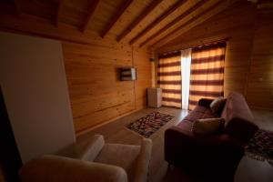 uma sala de estar com paredes de madeira, um sofá e uma janela em EM-BA BUTİK BUNGALOV em Demre