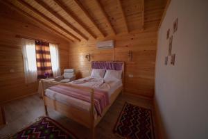 a bedroom with a bed in a wooden room at EM-BA BUTİK BUNGALOV in Demre