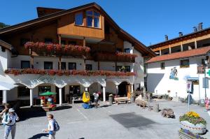 a large building with flower boxes on the side of it at Pensione Edelweiss in San Cassiano