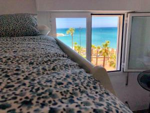 1 dormitorio con 1 cama y vistas al océano en Impresionante 1ª línea de playa..., en Fuengirola