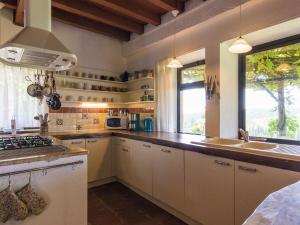 a kitchen with white cabinets and a sink and a window at Magnificent holiday home with pool in Thenon in Thenon