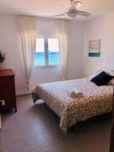 1 dormitorio con cama y ventana con vistas al océano en Impresionante 1ª línea de playa..., en Fuengirola