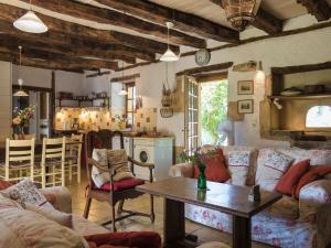 a living room with couches and a table and a kitchen at Magnificent holiday home with pool in Thenon in Thenon