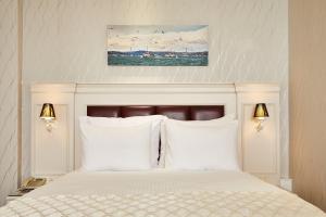 ein Schlafzimmer mit einem weißen Bett mit weißen Kissen in der Unterkunft Albinas Hotel Old City in Istanbul