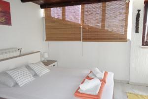 a white bedroom with a bed and a window at Apartment Beli Kriz in Piran