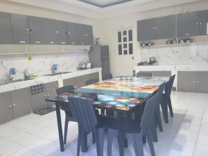 a kitchen with a table and chairs in a room at OMG Guesthouse Room for 6 in Licup