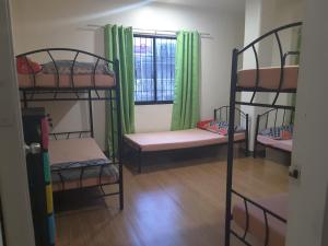 a room with four bunk beds and a window at OMG Guesthouse Room for 6 in Licup
