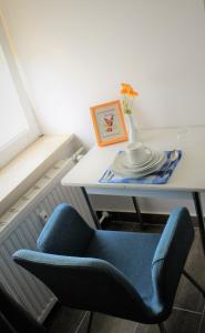 una mesa con una silla azul y un jarrón en ella en ZV-Scholtz Gästehaus Neuötting Simbacher Straße 7, en Neuötting