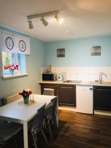 a kitchen with a table and chairs and a table and a table and a kitchen at Pokoje Morska Syrenka in Stegna