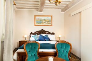 a bedroom with a bed with two chairs at Casa Dreosti in Cortona
