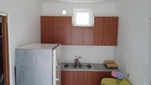 a kitchen with wooden cabinets and a stainless steel refrigerator at Keno's Apartment in Sarandë