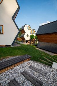 a backyard with a house and a building with a roof at Apartments Beeland Skok in Mozirje