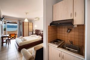 a room with a bed and a kitchen with a sink at Irini Seaside Studios in Nikiana