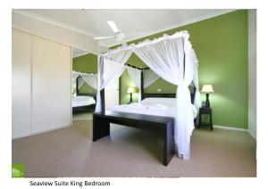 a bedroom with a canopy bed and a mirror at Southview Guest House in Wollongong