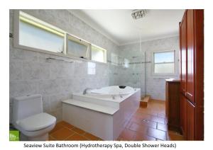 a bathroom with a tub and a toilet and a sink at Southview Guest House in Wollongong
