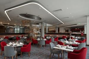 ダル・エス・サラームにあるCrowne Plaza - Dar Es Salaam by IHGのダイニングルーム(テーブル、赤い椅子付)
