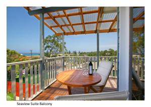 einen Holztisch und zwei Stühle auf einer Terrasse in der Unterkunft Southview Guest House in Wollongong