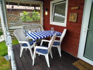 een tafel en stoelen op de veranda van een huis bij Ustka - Komfortowy domek nad morzem in Przewłoka