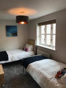a bedroom with two beds and a large window at 3 Crown Barton, Glastonbury in Glastonbury