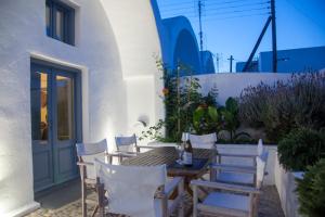 a patio with a table and chairs and a building at Onirondas Villas in Fira