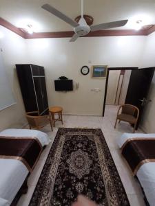1 Schlafzimmer mit 2 Betten und einem Deckenventilator in der Unterkunft المسرة سكن للعزاب فقط in Yanbu