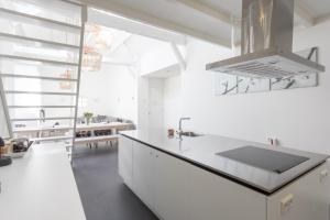a white kitchen with a sink and a counter at De Dorsvloer in Domburg