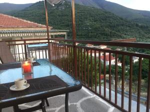 a table on a balcony with a view of a mountain at Annasol Maison in Kallirákhi