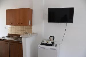 a kitchen with a flat screen tv on a wall at Ephelia gold in Laganas