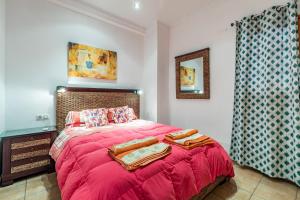 a bedroom with a bed with a red blanket at Beach Apartment with beautiful view in Port Saplaya