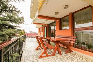 a wooden table and chairs on the balcony of a house at CASA SORICELU in Săcele