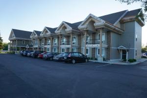 a large building with cars parked in a parking lot at CenterWay Hotel Buffalo North Near University in Tonawanda