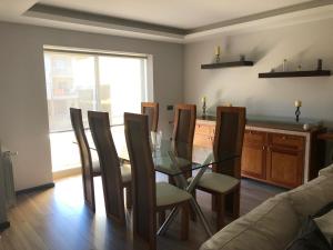 comedor con mesa de cristal y sillas en Orchidee Apartment, en Canedo