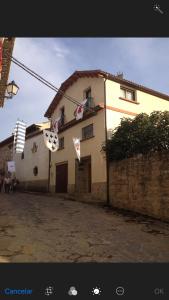 une maison avec des drapeaux accrochés devant elle dans l'établissement Casa Alaya, à Bailo