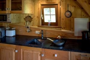 a kitchen with a sink and a clock on the wall at Chalet "Knusperhäuschen" in Murau