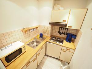 uma pequena cozinha com um lavatório e um micro-ondas em Appartement-67 em Westerland
