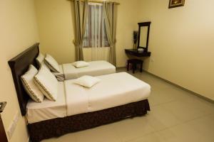 A bed or beds in a room at Jarzez Hotel Apartments Al Hail