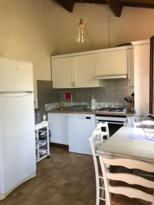 ガレリアにあるResidence Palmarella appartement 10のキッチン(白い家電製品、テーブル、椅子付)