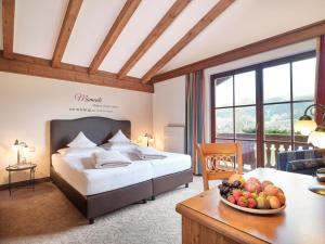 um quarto de hotel com uma cama e uma mesa com uma taça de fruta em Hotel Hubertus em Brixen im Thale