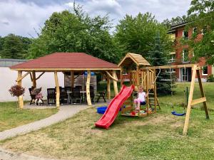 ein Kind, das auf einer Rutsche auf einem Spielplatz spielt in der Unterkunft Villa am Schwanenteich in Spremberg