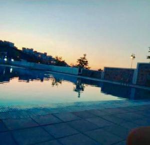 a pool of water with a sunset in the background at Complexe Lilia Al jabal in M'diq