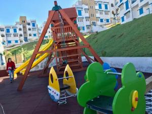een speeltuin met een glijbaan en een speelstructuur bij Complexe Lilia Al jabal in M'diq