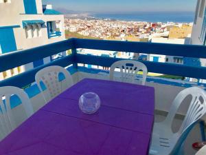 d'une table et de chaises violettes sur un balcon. dans l'établissement Complexe Lilia Al jabal, à M'diq