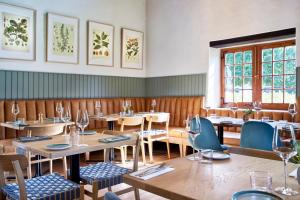 a restaurant with wooden tables and chairs and windows at Weltevreden Estate in Stellenbosch