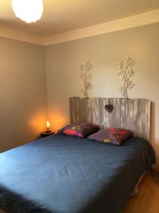 1 dormitorio con 1 cama con cabecero de madera en Chambre d'Hôtes Les Bruyères, en Cadouin