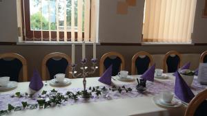 a table with purple napkins on top of it at Landpension Wendfeld in Sanitz