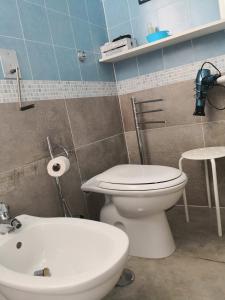 Łazienka z białą toaletą i umywalką w obiekcie Le Sirene Castellabate w mieście Santa Maria di Castellabate